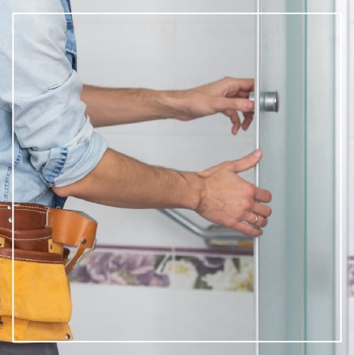 Man installing glass shower.