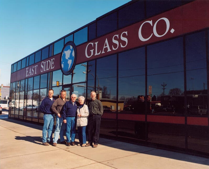 East Side Glass Building with Owners Standing in Front